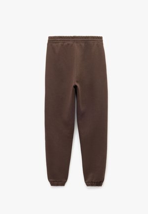 Pantalones de chándal marrones con una cinturilla elástica, piernas ajustadas y puños de canalé, hechos de una tela suave y texturizada.