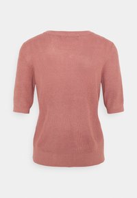 Lyhythihainen neulepusero pölyrose värissä, jossa on pehmeä rakenne, leveä pääntie ja rento istuvuus, jossa on hienovaraiset sivusaumat.