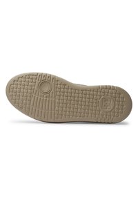 Schuhsohle aus strukturiertem beigem Gummi mit einem gemusterten Griff und einem kreisförmigen Emblem. Abgerundete Form mit leichter Krümmung zur Zehenpartie.