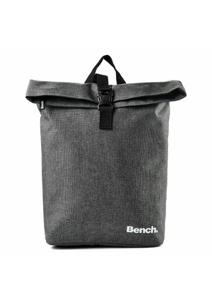Grauer Stoff-Rolltop-Rucksack mit schwarzem Schnallenverschluss, Tragegriff und weißem "Bench"-Logo unten rechts.