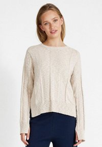 Beige gestrickter Pullover mit strukturiertem Finish, Rundhalsausschnitt, geripptem Saum und langen Ärmeln. Seitenschlitze sorgen für eine lässige Passform.