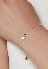 Złoty bransoletka z łańcuchem z małymi zawieszkami w kształcie serca i motyla. Gładka faktura, delikatny design, charakteryzuje się minimalnymi akcentami i różnymi kształtami zawieszek.