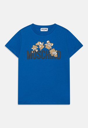 Blå kortærmet skjorte med fem animerede tøjdyr over den sorte tekst "MOSCHINO" på brystet.