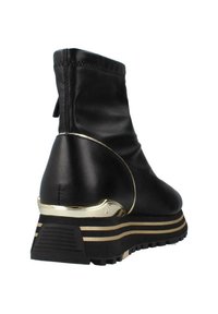 Stivaletto in pelle nera con un accento dorato sul tallone, caratterizzato da una suola testurizzata e strisce sovrapposte nere e dorate.