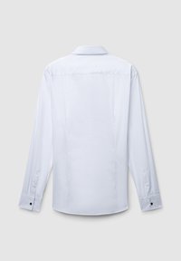 Camicia bianca a maniche lunghe, tessuto liscio, collo aperto, orlo arrotondato, due pieghe sul retro, polsino con bottoni neri di accento.