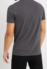 Krótki rękaw, dopasowana szara koszulka z miękkiej bawełny, z okrągłym dekoltem i starannym przeszyciem z tyłu.