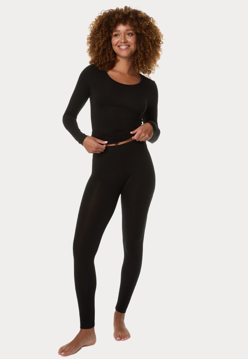 Černý top s dlouhými rukávy a odpovídající legíny vyrobené z měkkého, elastického materiálu; přiléhavý střih s kulatým výstřihem a bez viditelných vzorů.