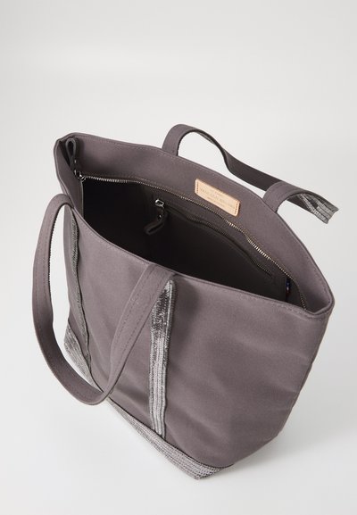 Gray canvas tote bag with contrasting metallic silver stripes, zippered pocket, and sturdy fabric handles. Interior features a simple design.