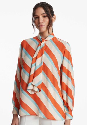 Blouse en soie à manches longues, ornée de rayures diagonales orange, bleu clair et crème, avec un col à nœud papillon.