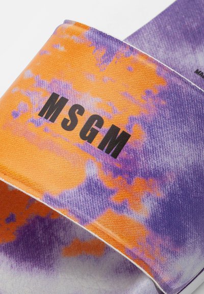 Chinelo slide em tie-dye roxo e laranja com uma textura suave e com a marca "MSGM" em preto, apresentando um design de tiras largas e uma construção robusta.