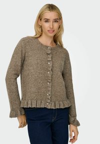 Brauner Strick-Cardigan mit Rundhalsausschnitt, Knopfverschluss und rüschenförmigem Saum sowie Ärmeln. Weicher Stoff und ärmellänge bis zur Mitte.