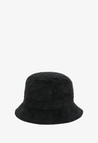 Cappello a secchiello in velluto a coste nero con una corona rotonda, ampia visiera e una trama rigata sottile. Presenta fori di ventilazione per la traspirabilità.