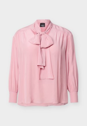 Lyserosa langermet bluse med rynkede skuldre, knappede mansjetter og en stor knyttet sløyfe ved halsen.