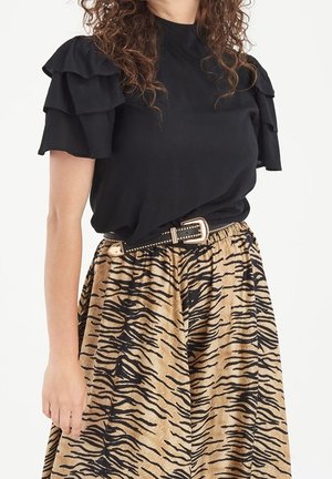 Blouse noire à manches volantées, assortie à une jupe beige ornée de rayures noires de tigre. Comprend une ceinture marron avec des accents dorés.