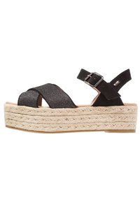 Czarne sandały na platformie z krzyżującymi się opaskami z brokatem, regulowanym zapięciem w kostce oraz plecioną wkładką z juty, z gładką gumową podeszwą.