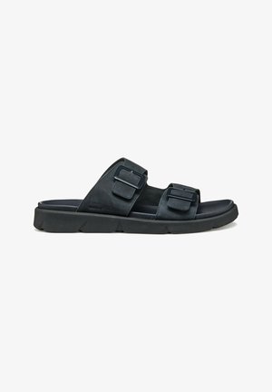Zwarte slip-on sandalen gemaakt van zacht materiaal met twee verstelbare gespsluitingen, een gevoerd voetbed en een gestructureerde rubberen zool.