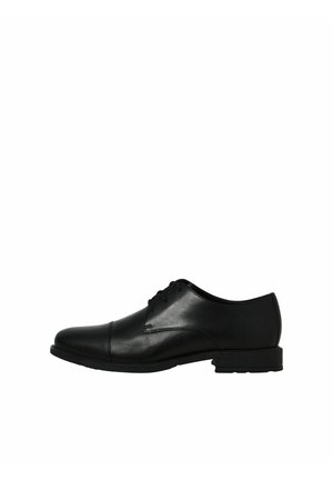Chaussure habillée pour homme en cuir noir avec fermeture à lacets à l'avant et petit talon, vue de profil sur fond blanc.
