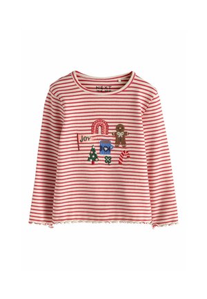 Langærmet rød- og hvidstribet skjorte med juletema patches inklusive en pebernøddefigur, juletræ, candycane og ordet "Joy."