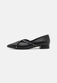 Ballerines en cuir noir avec un bout pointu, dotées de lanières croisées ornées de clous décoratifs et d'un petit talon carré.