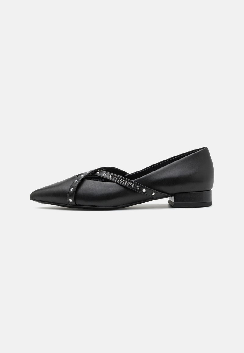 Ballerines en cuir noir avec un bout pointu, dotées de lanières croisées ornées de clous décoratifs et d'un petit talon carré.