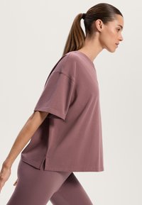 Løs siddende kortærmet t-shirt i mauve bomuld, med en rund halsudskæring og sideslids, parret med matchende leggings.