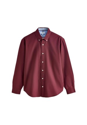 Burgundy pitkähiuksinen paita, joka on valmistettu puuvillasta, varustettu nappikauluksella, valkoisilla napeilla ja pienellä logolla rinnassa.