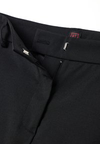 Pantaloni neri con una trama liscia, dotati di una cerniera frontale, un gancio in metallo e un'etichetta logo discreta di colore rosso.