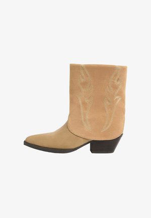 Bézs színű, velúr bokacsizma hegyes orral, a száron hímzett lángmintával és rétegezett sarokkal. Sima textúra és letisztult részletek.