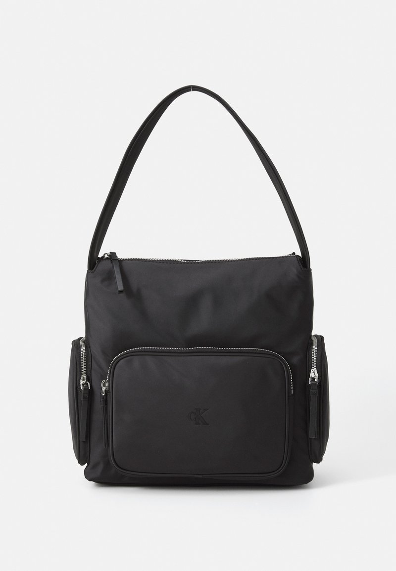 Zwarte nylon schoudertas met een ritssluiting aan de bovenkant, een voorkantvak en twee zijvakken met rits. Heeft een gladde textuur en een reliëflogo.