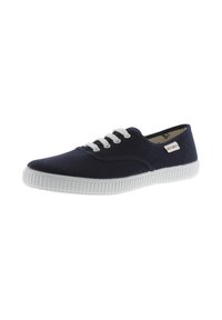 Sneaker in tela blu navy con suola in gomma bianca, cinque occhielli bianchi, dettagli cuciti e piccola etichetta colorata sul lato.