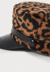Smešani smeđi i crni leopard uzorak šešir od filca s crnim kožnim obodom i trakom, s detaljem gumba sa strane.