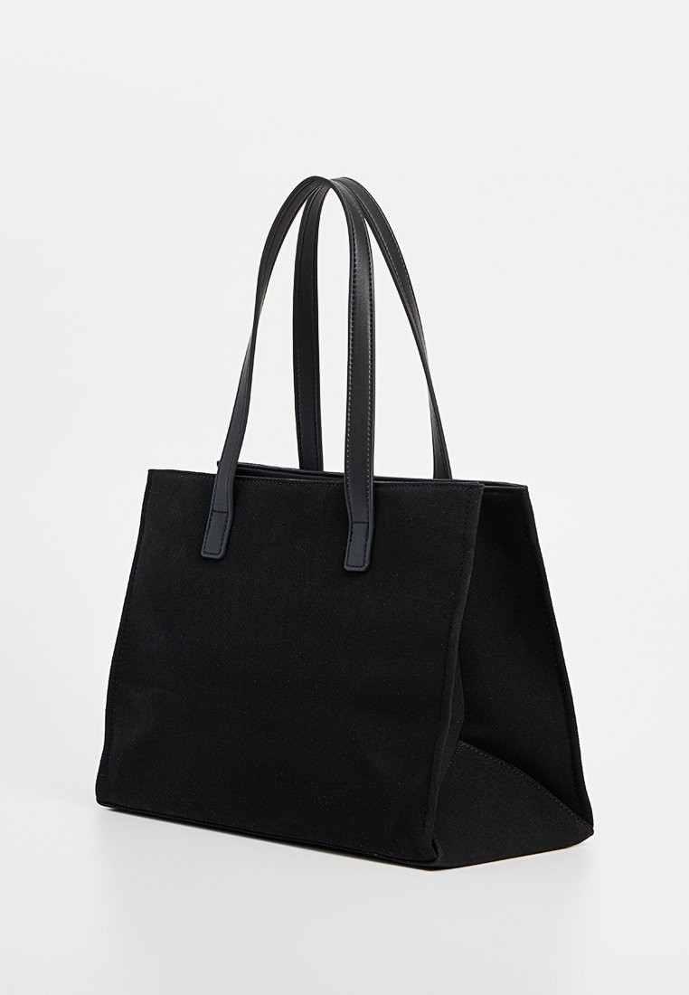 Schwarze Leinentasche mit glatten schwarzen Ledergriffen, strukturiertem Design und minimalistischer Gestaltung. Verfügt über ein geräumiges Innenfach zur Aufbewahrung.