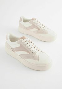 Sneaker basse con una combinazione di pelle bianca e suede rosa chiaro. Punta arrotondata, chiusura con lacci e suola spessa bianca.