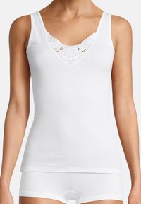 White cotton tank top with a V-neck and delicate floral embroidery at the neckline. Fitted design with narrow spaghetti straps.