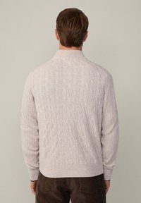 Hellgrauer Kabelstrickpullover mit hohem Kragen und gerippten Bündchen, versehen mit strukturierten Mustern und einer engen Passform. Geeignet für kühle Wetterbedingungen.