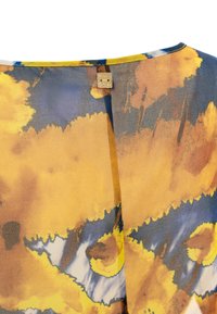 Blouse multicolore avec un motif abstrait jaune, bleu et marron, en tissu léger, et un détail de fermeture dorée à l'arrière.