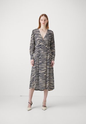 Pitkähihainen, vyötärölle sidottu mekko zebra-raidoilla, jossa on kermaista, laivastonsinistä ja vaaleaa väriä. Mekossa on runsaat hihat ja syvä V-pääkallo.