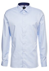 Lichtblauwe blouse met lange mouwen, van een solide textuur, met een button-down kraag en contrasterende marineblauwe stippenvoering aan de binnenkant van de kraag.