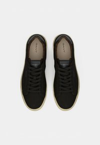 Schwarze Sneaker mit einer Mischung aus Wildleder und Leder, runder Zehenform und kontrastierender Sohle. Sie verfügen über runde Schnürsenkel und ein Logo auf der Zunge.