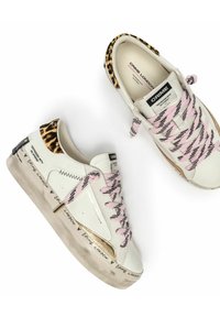 Sneaker bianche basse con lacci rosa e neri, dettagli in stampa leopardata, dettagli dorati e testo "Crime London" sulla suola e sulla linguetta.