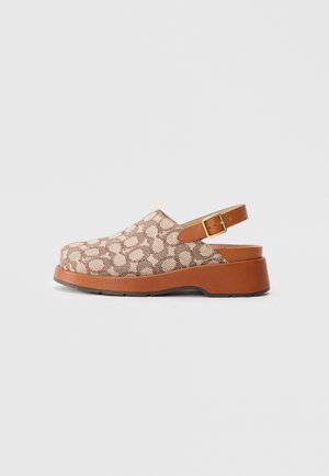 Clog marrone e beige a motivo testurizzato con una tomaia morbida, schiena aperta e una suola spessa in gomma marrone. Cinturino regolabile con fibbia dorata.