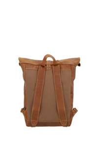 Brun läder- och tygryggsäck med rulltoppsdesign, justerbara remmar och ett handtag på toppen. Har kontrasterande sömmar och hållbara material.