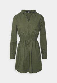 Abito camicia verde oliva in un tessuto leggero, con colletto, scollatura a V, maniche lunghe e vita arricciata, che si allunga fino a un orlo svasato.