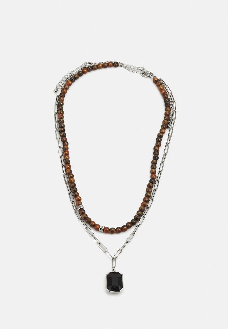 Colar em camadas com fios de contas castanhas e douradas, acompanhado por uma corrente de prata, realçado por um pingente octagonal de gemstone preto.