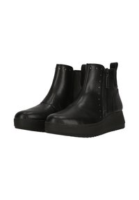 Botas de tobillo de cuero negro con punta redondeada, cremallera lateral, tachuelas decorativas y suela de goma gruesa para mayor altura y tracción.