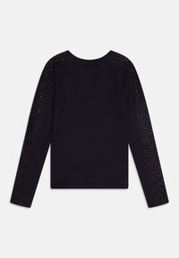 T-shirt noir à manches longues avec un corps côtelé et des manches accentuées de dentelle avec un motif floral. Encolure ras du cou. Coupe ajustée.