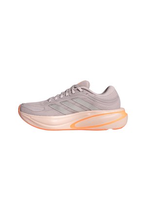 Hellvioletter Sportschuh mit dicker pfirsichfarbener Sohle und grauen Adidas-Streifen, von der Seite auf weißem Hintergrund gezeigt.