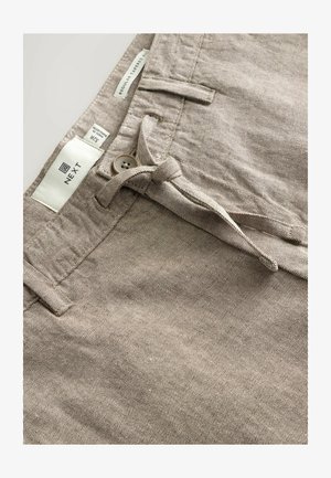 Bézs színű, szövött chino nadrág, normál, szűkített szabással. Barna gombos záródással, övbújtatókkal és 34-es méretjelzéssel ellátott címkével.