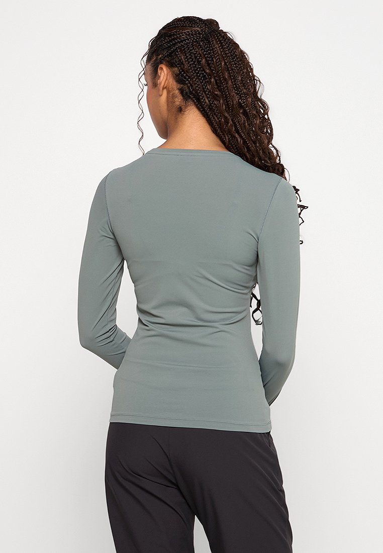 Langärmliges Oberteil aus weichem, hellgrünem Stoff. Mit rundem Ausschnitt und glatter Textur, designed für eine taillierte Silhouette.