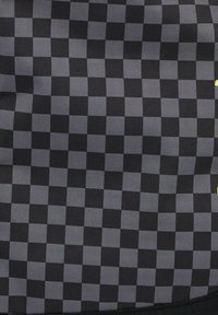 Black and gray checkered bag with a textured surface, featuring alternating squares and a smooth border. Includes a yellow accent detail.